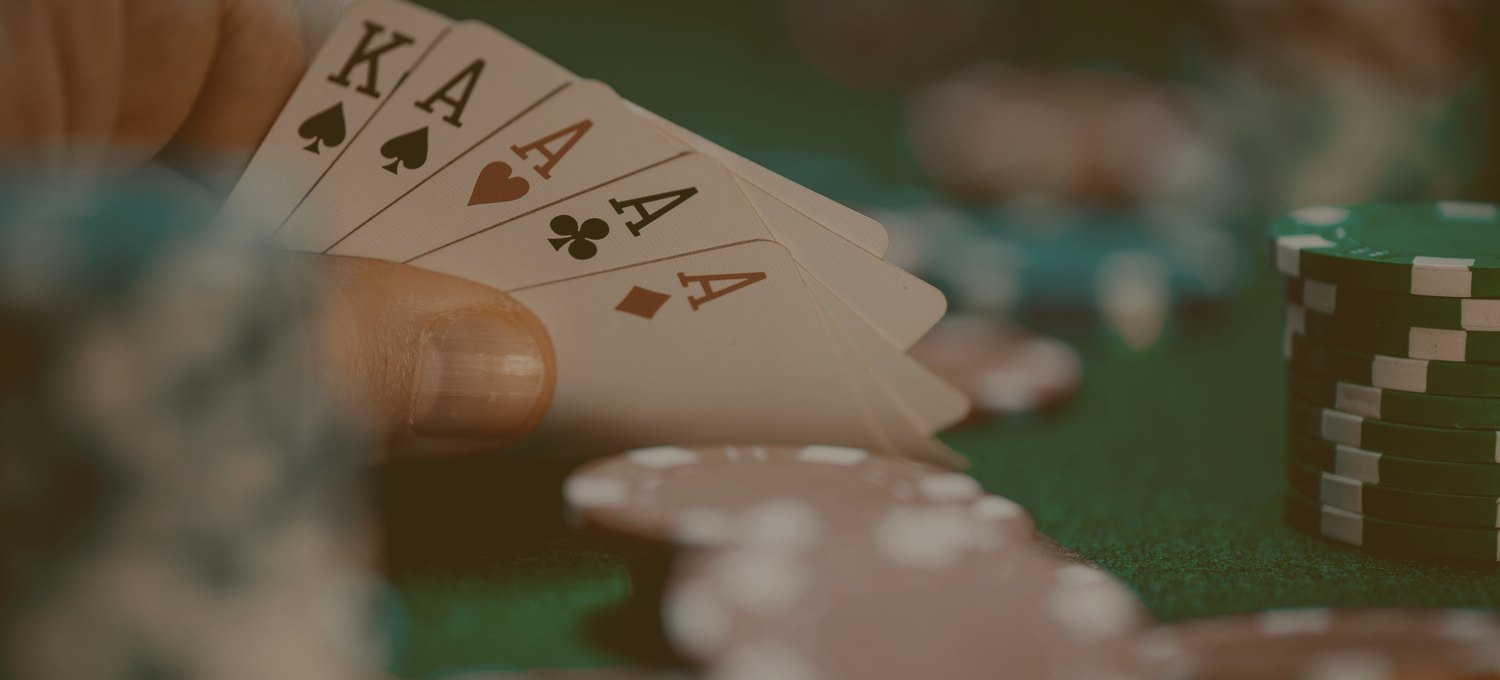 Cards and chips in low, warm light on a poker table